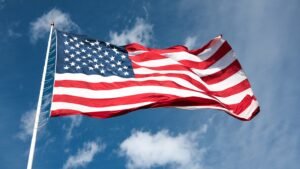 American Flag Blows in the Wind Against Cloudy Blue Sky